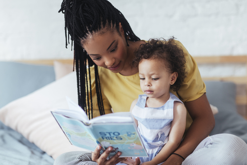 African American mom reading book to toddler girl