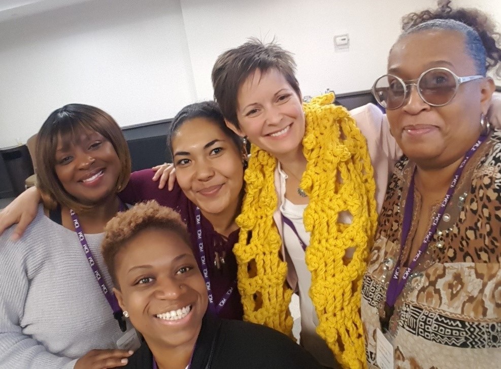 Group of four diverse women smiling and embracing