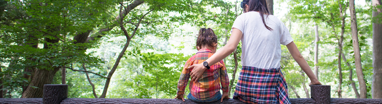 mom-and-daughter-sitting-on-a-fence-in-forest